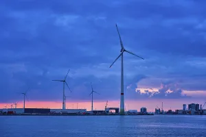 Wind turbines power electricity generators in Antwerp port in dusk