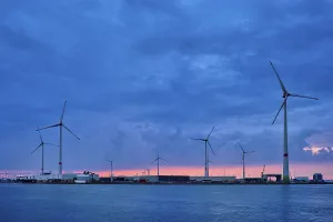 Wind turbines power electricity generators in Antwerp port in the evening