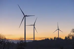 Three wind turbines in front of a vivid sunset