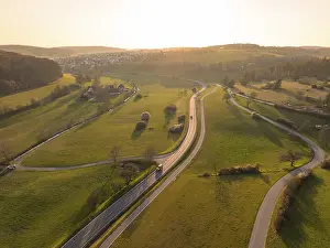 Winding country road through green fields and trees
