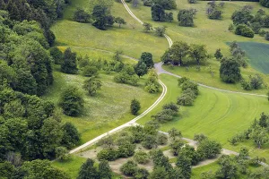 Winding paths lead through green fields and meadows