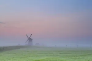 Windmill silhouette over sunrise sky