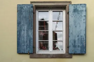 Window with blue shutters and reflections