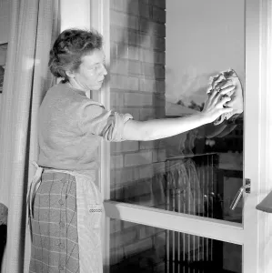 Windowcleaning in the 1950s. A woman is seen cleaning the windows of her apartment. 11 january 1955