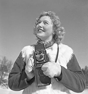 Winter in the 1940s. A young woman is photographing on a winter day