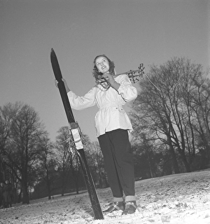 Winter in the 1940s. A young woman is wearing the typical 1940s winter sports clothes. Dressed in a practical wind jacket, ski pants and with a pair of skis and poles. Sweden 1948. Photo Kristoffersson ref Y10-4