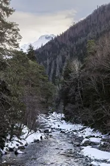 Winter landscape of a mountain river with snow along the coast