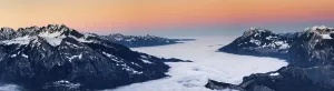 Winter mountain landscape at sunset with cloud cover in the valley below in the Rhine Valley in Switzerland