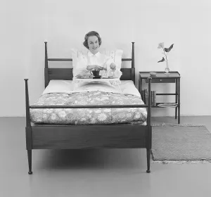 Woman of the 1950s. A young woman in bed with breakfast served for her on a tray