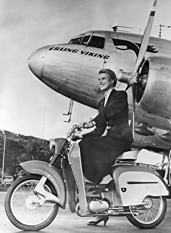 Woman of the 1950s. A young woman with a new Monark moped in front of a passenger plane