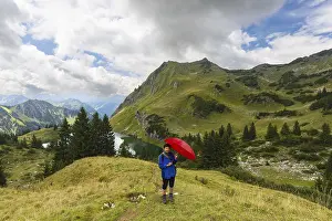 Woman 60-65 hiking with umbrella