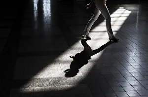 Woman casting a shadow on the floor of a building