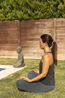 A woman in a casual workout outfit is engaged in the Sukhasana (Easy Pose)
