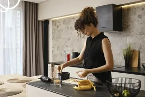 A woman with curly hair is carefully creating a nutritious snack