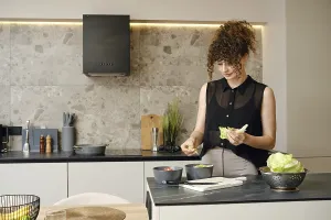 Woman with curly hair prepares a fresh salad in a contemporary kitchen