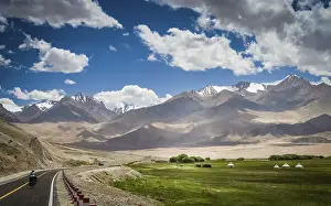 Woman cyclist on stunning KKH road through Karakorum mountains in southern China