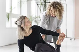 Woman doing yoga with teacher