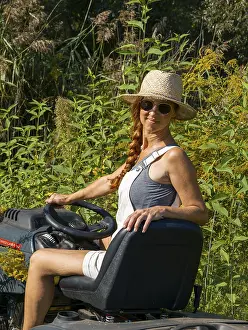 Woman driving lawn mower, lawn tractor