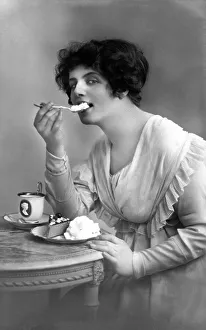 Woman eating cake with cream, 1910s