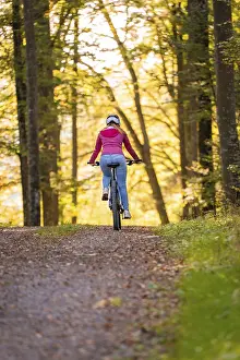 Woman on Ebike through the autumn forest