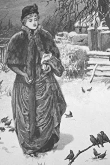 Woman feeding the wild birds in the park in winter