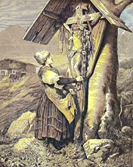 Woman in front of a field cross in the Alps