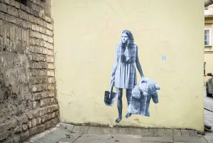 Woman holding bear and spade. Painting on wall