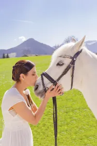 Woman kisses white horse