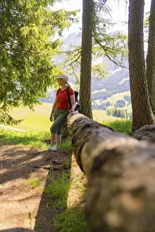 Woman leaning against a tree trunk