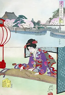 A woman leans lightly forward to play a koto