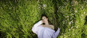 A woman lies in a field of green plants
