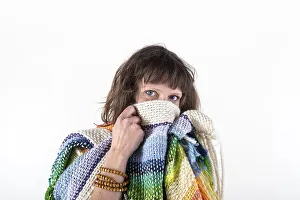 Woman looking at camera while putting her scarf over her mouth
