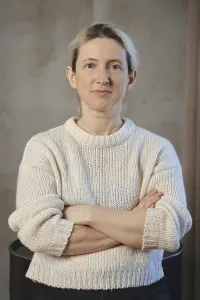 A woman poses confidently with her arms crossed