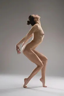 A woman poses in a studio, demonstrating her athletic ability and strength through a dynamic stance