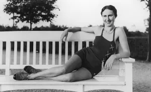 Woman posing in a bathing suit on a white park bench