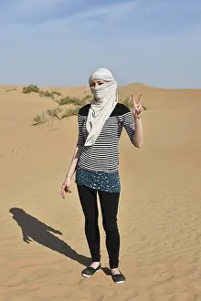 Woman posing in the sandy desert of Dubai