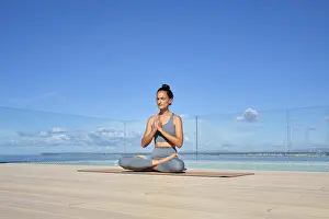 A woman practices meditation on a rooftop deck