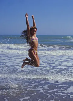 Woman by the sea, jumping