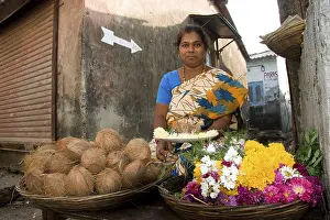 Woman selling flowers and coconuts
