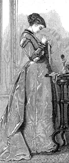 Woman at sewing work, in a long dress after the fashion around 1869 in France