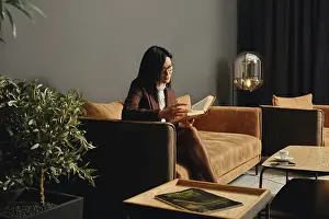 A woman sits comfortably on a modern couch
