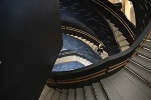 Woman on spiral staircase printed with Finnish words