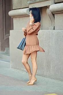 A woman is standing on a city sidewalk
