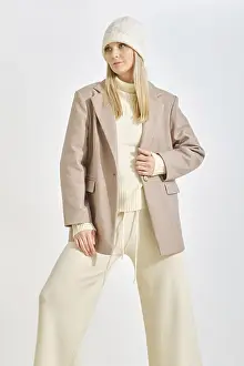A woman stands confidently in a cozy winter outfit