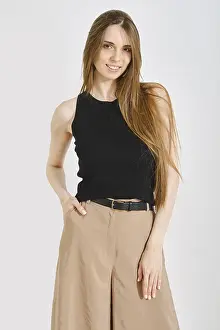 A woman stands confidently in a trendy female outfit