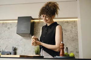 A woman stands in a stylish kitchen