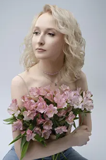 A woman with wavy blonde hair sits thoughtfully