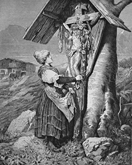 Woman in front of a wayside cross in the Alps