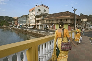 Woman in yellow saree going to work over Old Pato bridge, Yellow bridge on the Mandovi River, Mahatma Gandhi Road, old Portuguese structure, Panjim, Goa, India, Asia