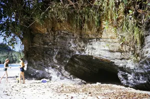 Two women on beach wearing swimwear next to cave, Las Cuevas, Trinidad, Trinidad and Tobago 1961-1963